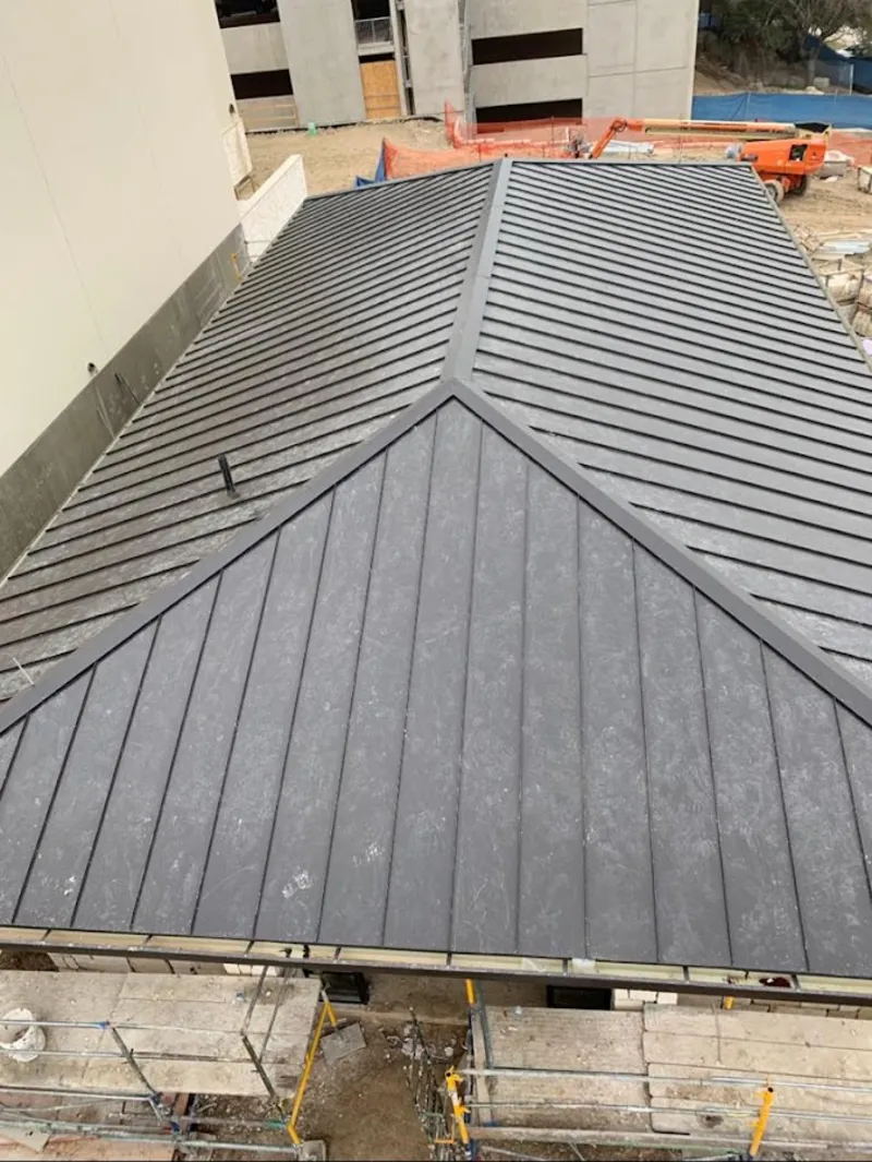 Commercial metal roof construction with crane equipment in Seven Oaks